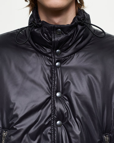 Black puffer jacket detail with high drawcord collar and snap-button front
