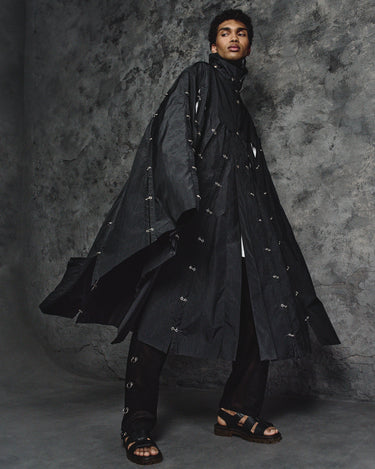 Long hooded dark cape with front button placket and scattered silver details