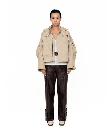 Beige hooded jacket with flap chest pockets, snap front, and shoulder epaulet details