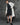 White balmacaan coat with button front and notched collar, worn over dark outfit