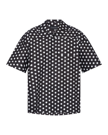 Black camp shirt with white dot print, short sleeves and button-front placket.