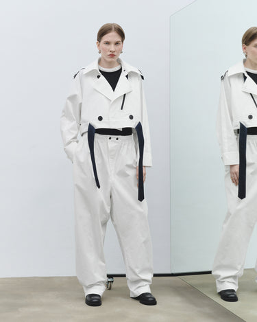White cropped trench jacket with wide collar and black belt-like straps