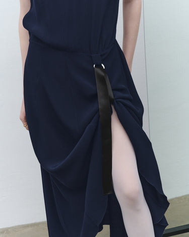 Navy fluid midi dress close-up: draped tie detail and long side slit