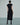 Back view of a black fringed dress with short sleeves and a midi-length hem