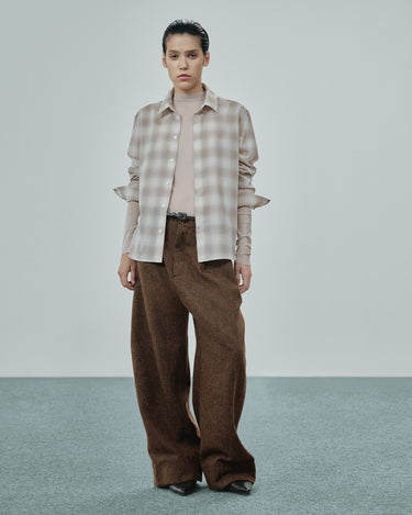 Beige plaid button-up shirt worn with wide-leg brown trousers