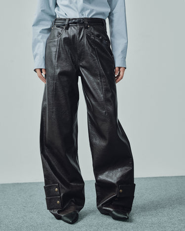 Black loose-fit faux leather pants with wide legs and stitched panel seams