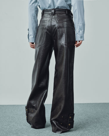 Black wide-leg faux leather pants with belt loops and double snap cuff tabs