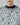 Ivory shredded knit sweater close-up with crew neckline and ragged layered texture