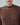 Brown cable-knit sweater with chunky cable texture and ribbed crew neckline