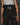 Black apron detail view: top flap with snap buttons and front belt with metal buckle