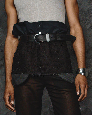 Black apron detail view: top flap with snap buttons and front belt with metal buckle