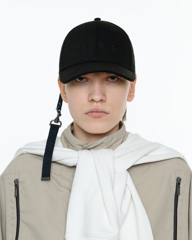 Black baseball cap with keychain strap and clip at the side