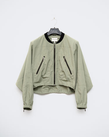 Light green cropped bomber jacket with black collar, front zipper, and zip pockets