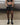 Black faux-leather mini shorts with front pockets and ring-buckle belt
