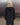 Dark hooded wind shell jacket on model, back view showing hood opening.