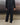 Black track pants with elastic waistband and wide relaxed leg opening, back view