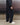 Black track pants with gathered elastic cuffs and relaxed silhouette, side view