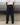 Black track pants with elastic waist and tapered hem, worn with sneakers
