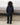 Black track pants with elastic waistband and full-length relaxed fit, back view