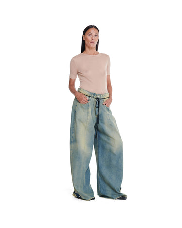 Washed blue distressed baggy jeans, wide leg silhouette with black drawstring tie.