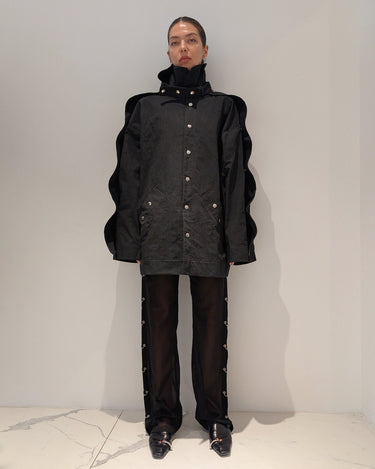 Elongated black jacket with stand collar, button front, and long sleeves