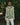 Light green hooded puffer vest on model; zip front with two zip pockets.