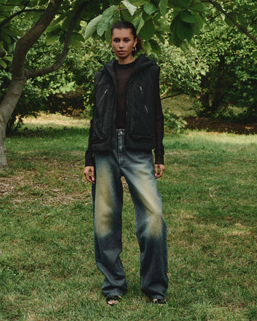 Black hooded vest on model with full-zip front, hood, and side zip pockets