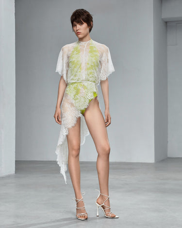 White lace dress with sheer overlay, neon-lime embroidered pattern, cape sleeves