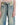 Washed blue distressed baggy jeans with black drawstring, front patch pockets.