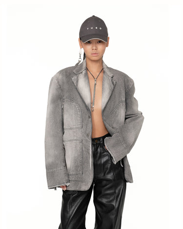 Men's gray denim jacket close-up with notch lapels, chest flap pockets, and buttons