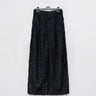 Black fringed texture trousers hanging, shown from the front.