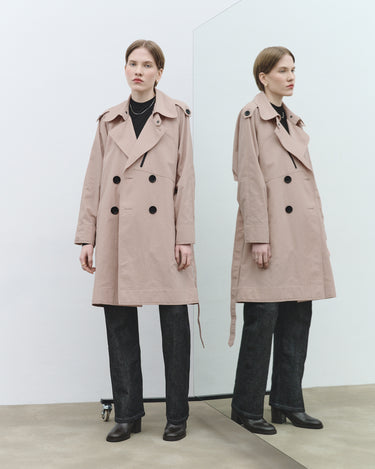 Nude textured trench coat with black button closure, notched collar, and long sleeves.