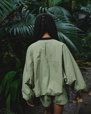Light green bomber jacket worn back view, with front zipper and elastic cuffs