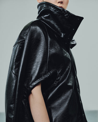 Black eco-leather cape with wide sleeves and high hood with snap closures