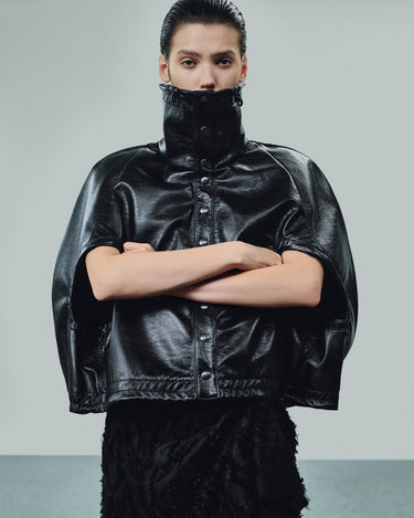 Black eco-leather cropped cape with high collar, snap front, and gathered cuffs