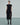 Front view of a black fringed dress with a thigh-high slit