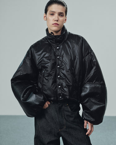 Black puffer jacket with snap front, high collar and oversized leather-look cuffs