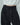 Close-up of the black fringed trousers' button waistband and textured fabric.