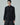 Front view of a black fringed shirt with long sleeves, high collar, and button front.