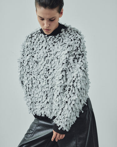Ivory and black shredded sweater with crew neck and long ragged fringed sleeves