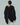 Textured black draped sweater with olive knit accents, shown from the back