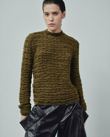 Olive green cable-knit sweater with long sleeves and ribbed hem