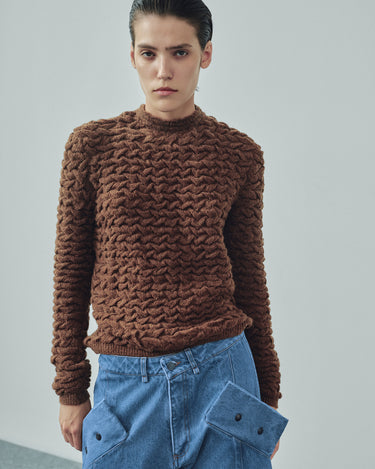 Brown cable-knit sweater with textured cable pattern at the front
