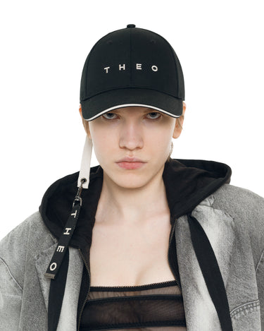 Black baseball cap with THEO logo, keychain tag and metal clasp visible