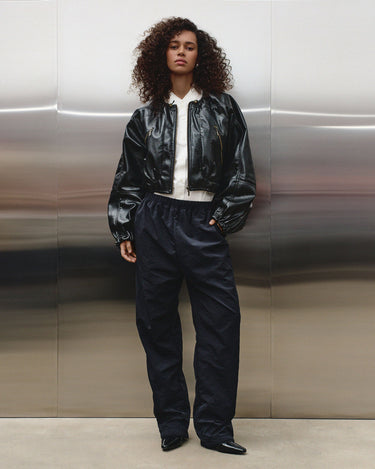 Black balloon jacket with front zip and stand collar over a white top