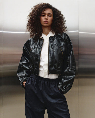 Black balloon jacket with front zip and elastic waistband at the hem