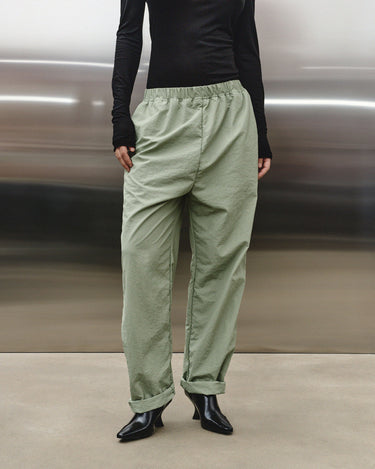 Light green track pants from the front, elastic waistband and ankle cuffs