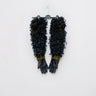 Black leather gloves with heavily textured ruffled cuffs and olive knit trim