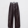 Dark brown loose-fit faux leather pants with wide legs and side seam pockets