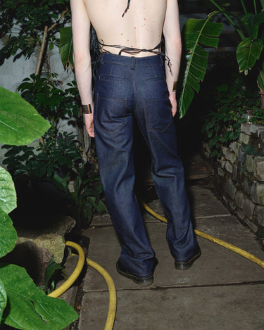 Navy six-pocket denim jeans on model, relaxed straight fit